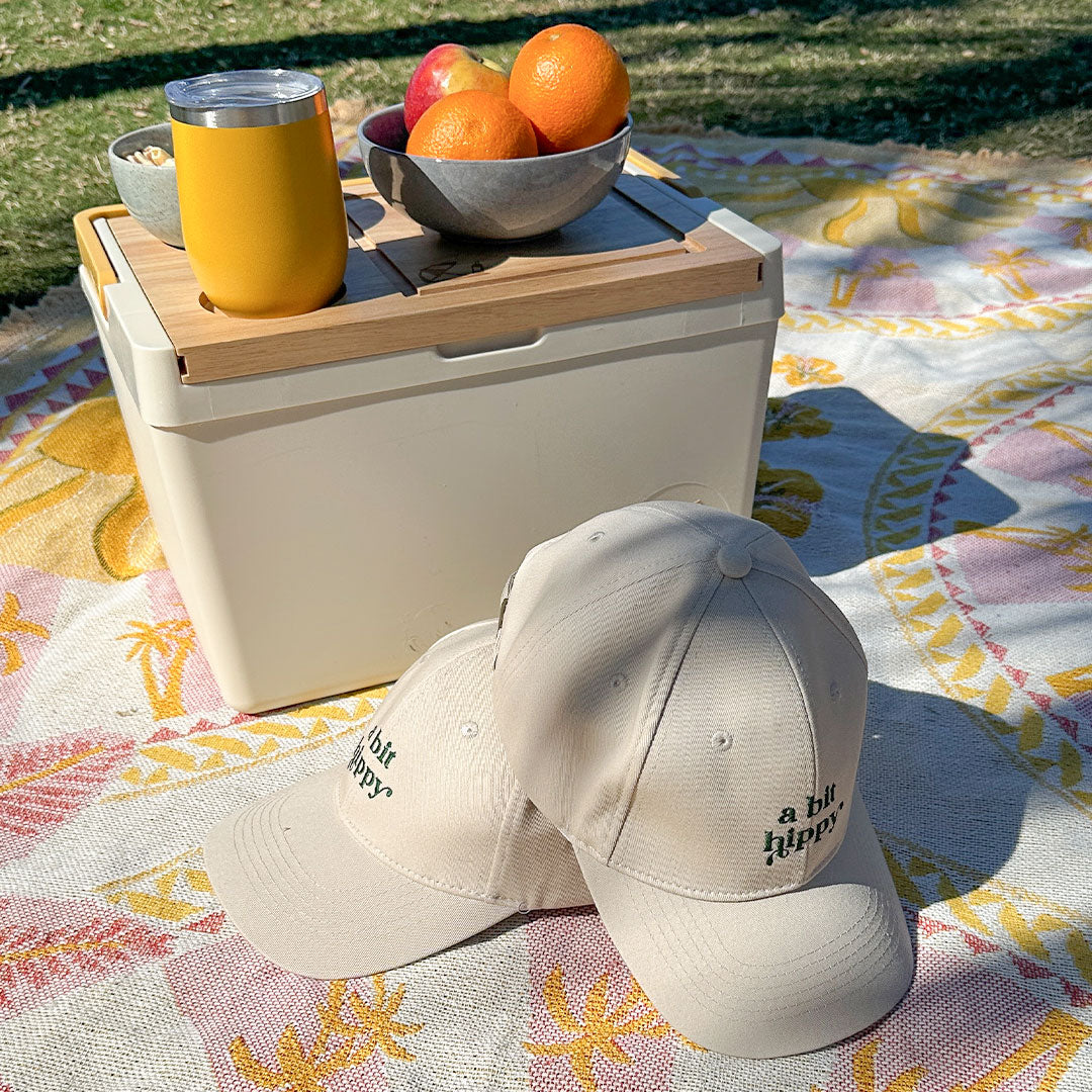 A Bit Hippy Cap eco hats on picnic rug, natural cotton headwear designed for UV protection, stylish outdoor caps for summer activities.