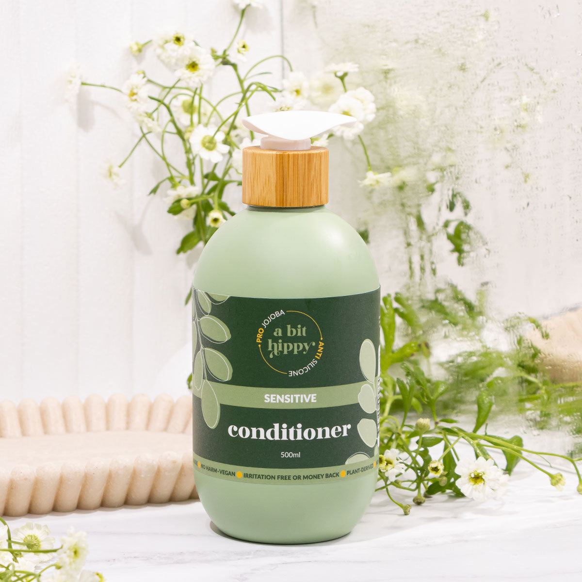 A bit Hippy Conditioner on bathroom sink, gentle, silicone-free formula with Jojoba, Rapeseed and Vitamin B5 to hydrate, strengthen and curb split ends