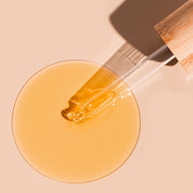 A bit Hippy Face Oil swatch on peach background, golden oil with Vitamin C and E along with Rosehip to improve skin elasticity and promote regeneration.