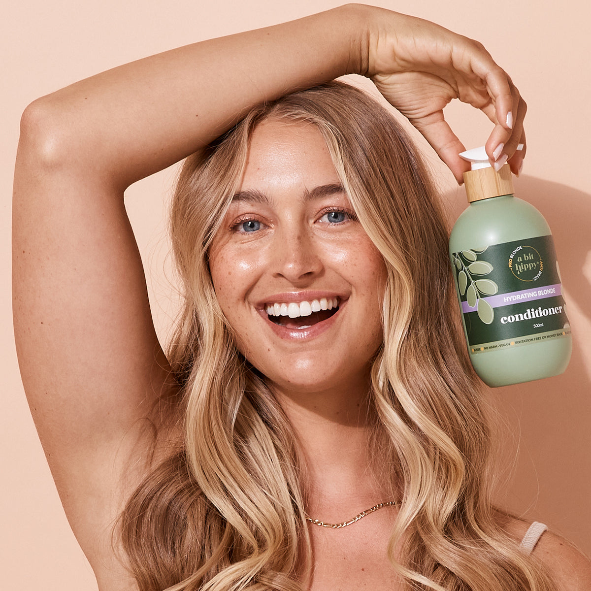 Model holding A bit Hippy blonde conditioner for hydration and toning, natural haircare.