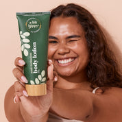 Happy woman showcasing A bit Hippy Body Lotion in sustainable bamboo-cap tube, natural lotion with chamomile and niacinamide